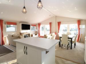 a kitchen and living room with a table and chairs at Broadland Sands Lodge in Lowestoft