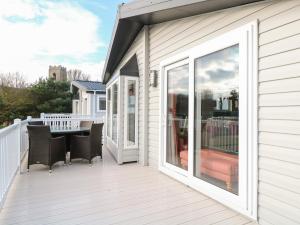 a patio with a table and chairs on a deck at Broadland Sands Lodge in Lowestoft