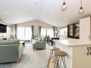 cocina y sala de estar con sofás y mesas. en Broadland Sands Lodge, en Lowestoft