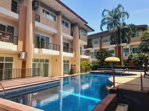 a swimming pool in front of a building at Thalassa Kata Beach in Kata Beach