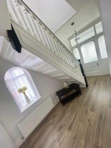 Habitación con escalera, ventana y mesa. en Croyden villa en Blackpool