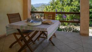 una mesa con 2 sillas y un bol en el patio en Welcomely - Country House Muristene, en Dorgali