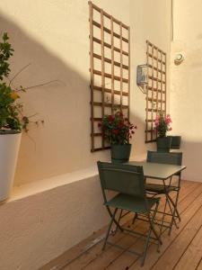 a table and chairs with potted plants on a wall at Villa TerraMera Hôtel in Le Lavandou