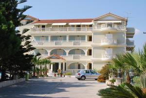 a large white building with a car parked in front at Hotel Villa Basil in Tsilivi
