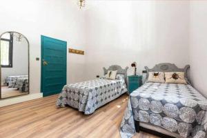 1 dormitorio con 2 camas y espejo en MonKeys Apartments Betis Chill Out, en Sevilla