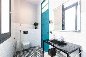 baño con lavabo y puerta azul en MonKeys Apartments Betis Chill Out, en Sevilla