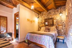 a bedroom with a bed in a stone wall at Hotel Amor y Paz - Adults Only in Real de Catorce