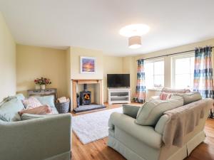 a living room with two couches and a fireplace at South Balachladich in Muir of Ord