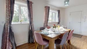 uma sala de jantar com uma mesa de madeira e cadeiras em Beautiful & Spacious with 2 Free Parking Spaces - SRK Accommodation em Peterborough