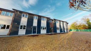 a row of buildings on a gravel street at Beautiful & Spacious with 2 Free Parking Spaces - SRK Accommodation in Peterborough