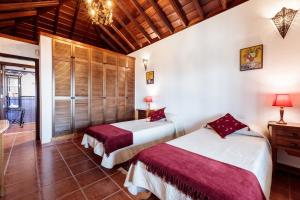 Casa Don Rodnico في Lodero: سريرين في غرفة بسقوف خشبية