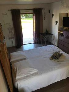 ein Schlafzimmer mit einem großen weißen Bett und einem Fenster in der Unterkunft chambre d hôtes les trois châteaux piscine intérieure chauffée in Notre-Dame-de-Riez