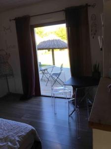 a room with a patio with an umbrella and a table and chairs at chambre d hôtes les trois châteaux piscine intérieure chauffée in Notre-Dame-de-Riez