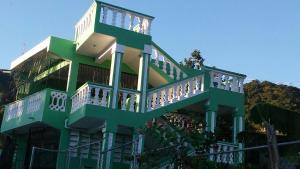 un edificio verde y blanco con balcón en Villa Valencia - 3 Habitaciones - 1ª Planta, en Los Patos