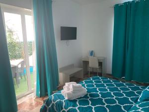 - une chambre avec des rideaux bleus et un lit avec des serviettes dans l'établissement Residence R&B Tyrrhenum, à Monte di Procida