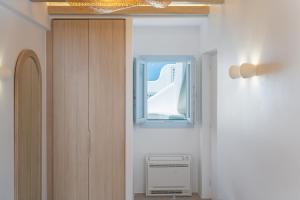 przedpokój z oknem w pokoju w obiekcie Airth Santorini Suites w mieście Firostefani