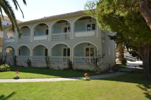 a large white house with a yard with a fire hydrant at Hotel Villa Basil in Tsilivi