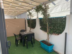 einen Tisch und Stühle in einem Zimmer mit Pflanzen in der Unterkunft Residence R&B Tyrrhenum in Monte di Procida