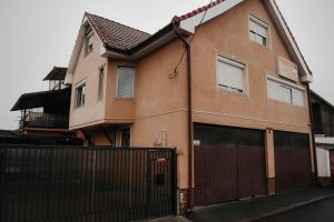una casa marrón con una puerta y una valla en Vila Delia, en Oradea