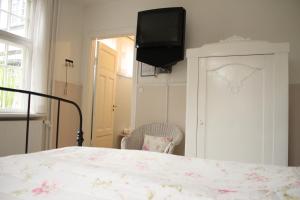 een slaapkamer met een bed en een tv aan de muur bij Hotel Egeskoven in Viborg