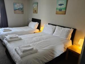 two beds in a hotel room with towels on them at Royal Albion Walton in Walton-on-the-Naze