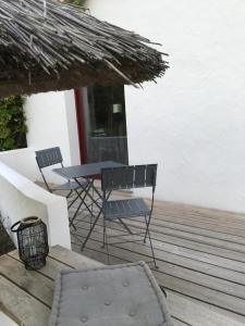 a patio with a table and chairs on a deck at chambre d hôtes les trois châteaux in Notre-Dame-de-Riez