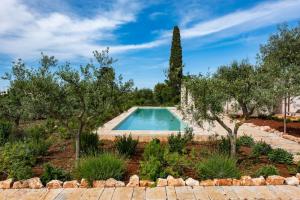 una piscina en un jardín con árboles en Ulivo, en Monopoli