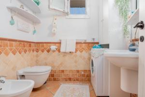 a bathroom with a toilet and a sink at Il Giardino di Viola in Porto Ottiolu +16 photos
