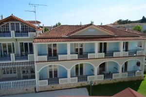 a large white building with a red tile roof at Hotel Villa Basil in Tsilivi