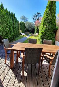 une table et des chaises en bois sur une terrasse en bois dans l'établissement Cypress Garden, à Portorož