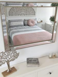 - une chambre avec un grand miroir au-dessus d'un lit dans l'établissement Ático Orquídea, à El Médano