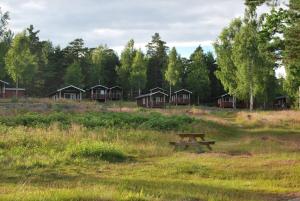 a picnic table in a field next to a group of cabanas at Ämtöstugorna in Gryt