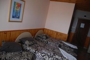 Duas camas num quarto com uma fotografia na parede em Хотел Варненци em Lŭki