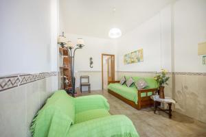 a living room with a green bed and a couch at Villas Brites nº2 in Burgau +21 photos