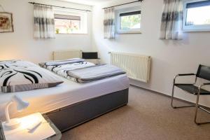 two beds in a room with a desk and a chair at Ferienwohnung am Greifswalder Bodden in Lubmin