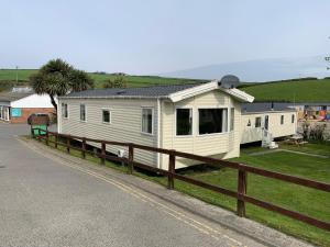 a white house on the side of a road at Newquay Bay Resort - Sea Breeze 61 in Newquay