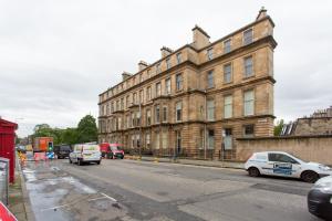 a large brick building with cars parked in front of it at Exclusive 2 Bed, Free Private Parking, in West End in Edinburgh