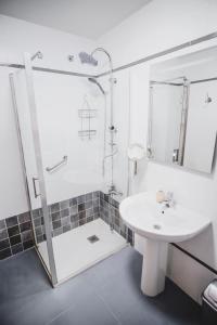een witte badkamer met een wastafel en een douche bij Palacio de Dueñas Private Terrace in Sevilla