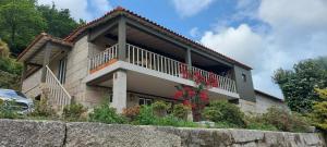 ein Haus mit einem Balkon mit Blumen darauf in der Unterkunft Casas da Tapada Briteiros Casa das Cortes in Guimarães