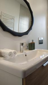 y baño con lavabo blanco y espejo. en Le Jardin de Moulis - Maison d'hôtes au pied des Pyrénées, Ariège, Saint Girons, en Moulis