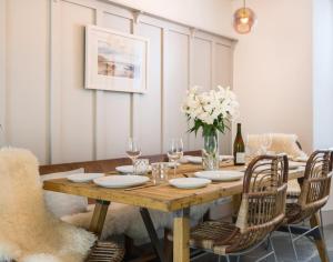 a wooden table with chairs and a vase of flowers at Albany in Port Isaac