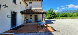 a building with a porch with blue tables on it at Agriturismo La Bella in Follina +34 photos