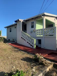 une maison avec un balcon sur le côté de celle-ci dans l'établissement Pine Breeze Apartments, à Bridgetown