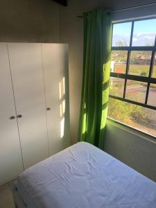 - une chambre avec un lit et une fenêtre dans l'établissement Pine Breeze Apartments, à Bridgetown