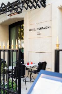 a hotel montclair with a table and chairs outside at Hotel Montaigne in Paris