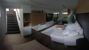 a living room with a white couch and a television at New Apartment Apartament modern recent construit Modern újépítésű társasházi lakrész in Miercurea-Ciuc