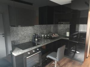 a kitchen with black cabinets and a counter top at New Apartment Apartament modern recent construit Modern újépítésű társasházi lakrész in Miercurea-Ciuc