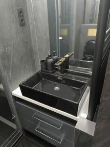 a black sink in a bathroom with a mirror at New Apartment Apartament modern recent construit Modern újépítésű társasházi lakrész in Miercurea-Ciuc