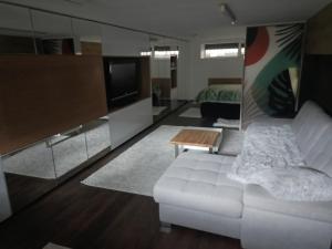 a living room with a white couch and a tv at New Apartment Apartament modern recent construit Modern újépítésű társasházi lakrész in Miercurea-Ciuc +10 photos