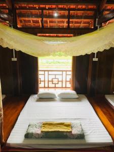 ein großes Bett in einem Zimmer mit Fenster in der Unterkunft Bac Son Homestay in Bắc Sơn